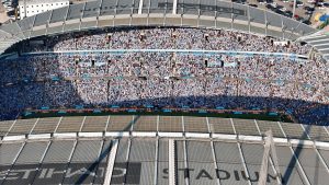 Aerial shot of Etihad Stadium filled with soccer fans in Manchester, UK.